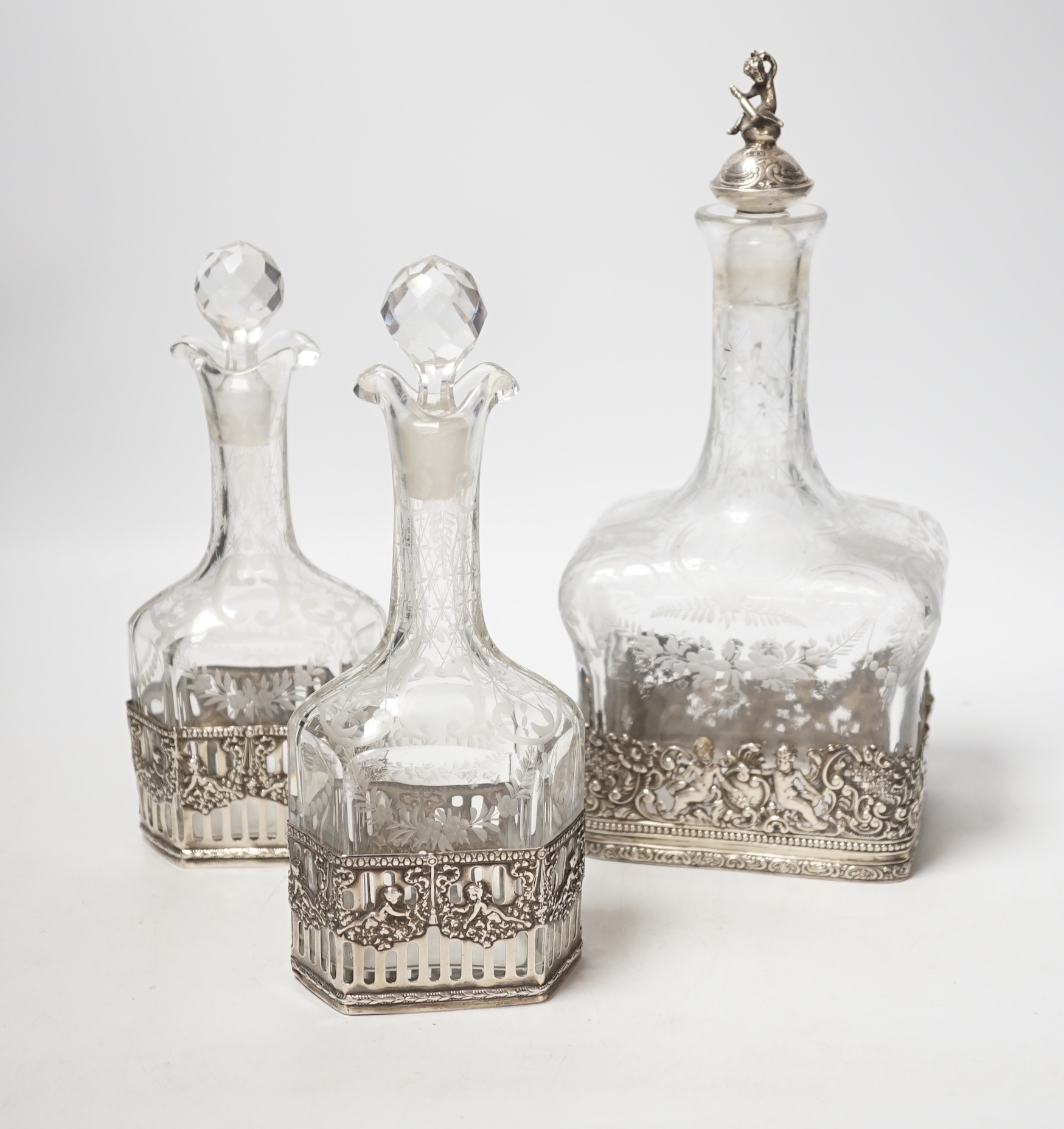 A George V Hanau silver mounted etched glass three piece decanter suite, import marks for Berthold Hermann Muller, London, 1912, tallest 26.5cm (neck broken).